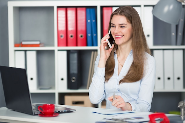 Empresária falando smartphone escritório e sorriso