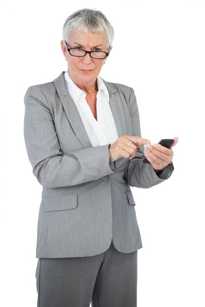 Empresaria con gafas utilizando su teléfono móvil