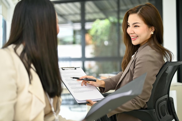 A la empresaria le gusta hablar con su colega mientras trabaja en la oficina