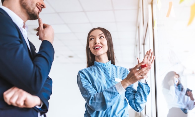 Foto la empresaria hablando con un hombre cerca del cristal.