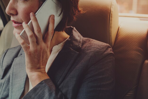 Empresaria hablando por teléfono dentro del coche