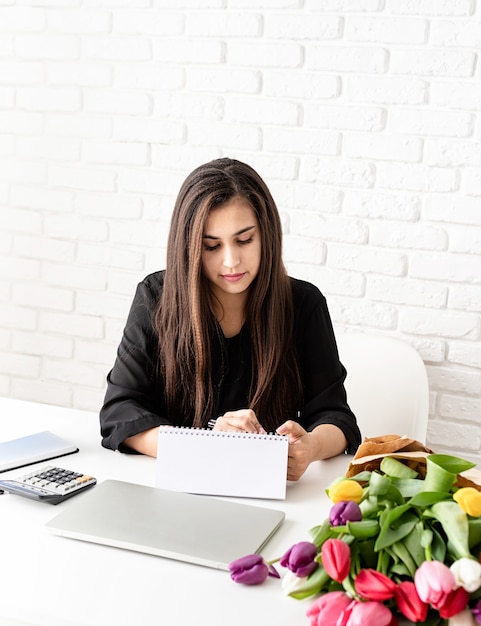 La empresaria haciendo notas en el calendario de escritorio en blanco