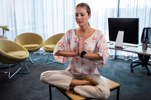 Empresaria haciendo yoga con las manos atadas