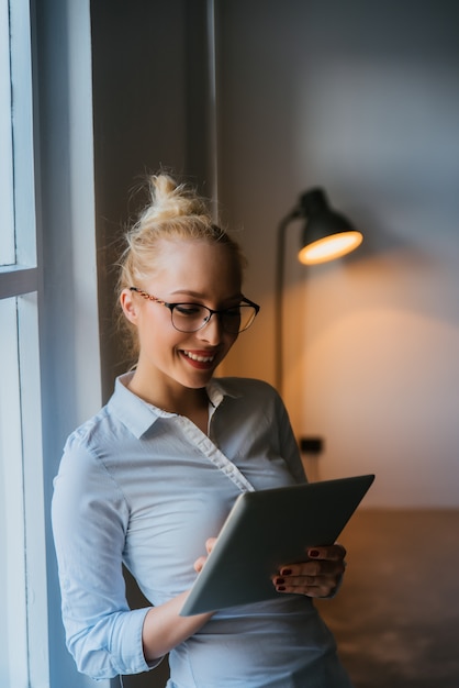 Empresaria hermosa que usa la tableta en oficina