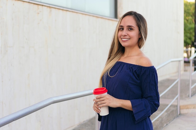 Empresaria hispnica con un café caminando por la calle