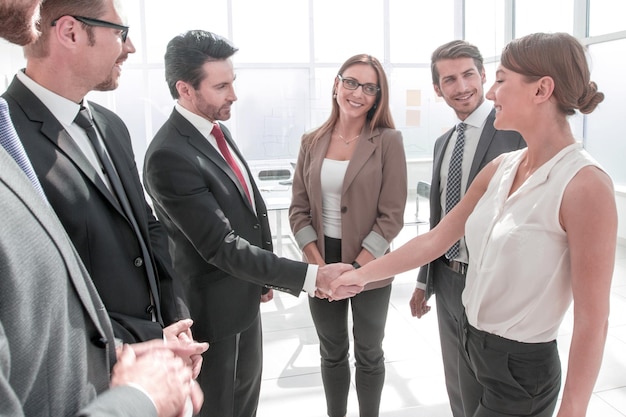 Empresaria y hombre dándose la mano en la oficina