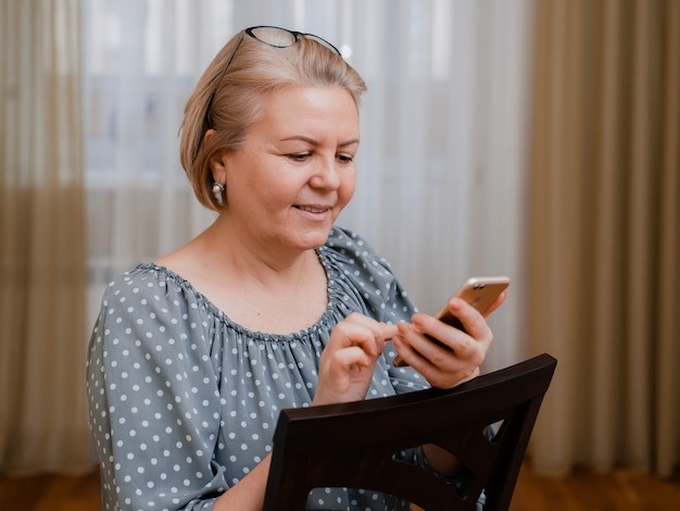 Empresária idosa atraente com um telefone móvel sorrindo