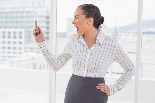 Empresária irritada gritando com seu telefone