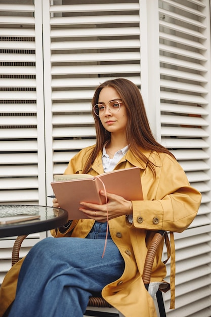 Empresária jovem confiante fazendo anotações no bloco de notas e pensando no plano de negócios