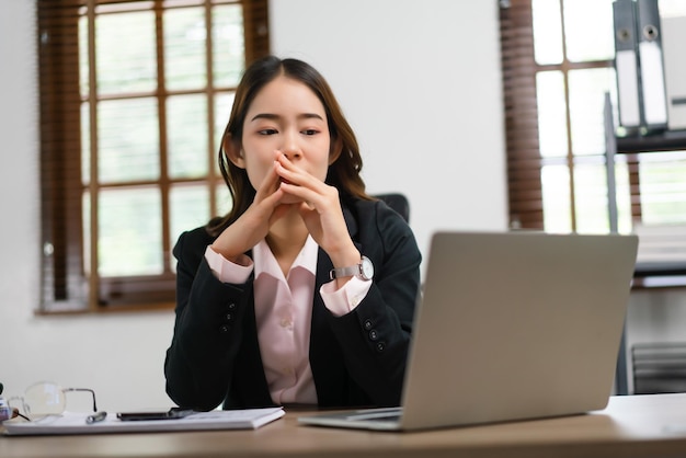 Empresaria leyendo datos financieros en una computadora portátil para planificar el plan de marketing de un nuevo proyecto de inicio