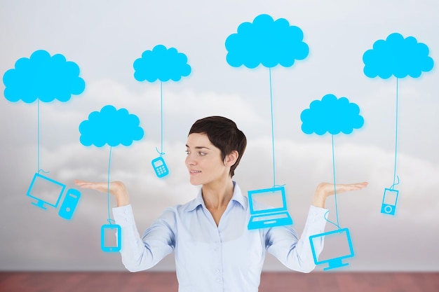 Empresaria con la mano abierta para mostrar gráficos contra las nubes en una habitación