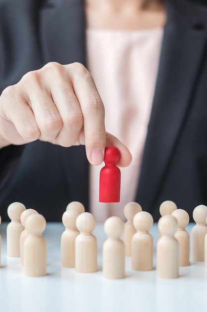 Foto empresaria mano tirando líder hombre madera de multitud de empleados toxic people gestión de recursos humanos reclutamiento trabajo en equipo y liderazgo conceptos