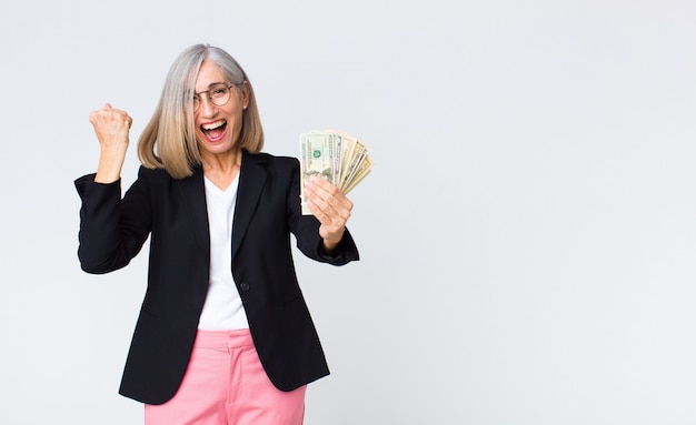 Foto empresaria de mediana edad con billetes de un dólar