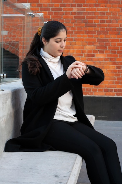 Empresaria mirando su reloj de pulsera al aire libre