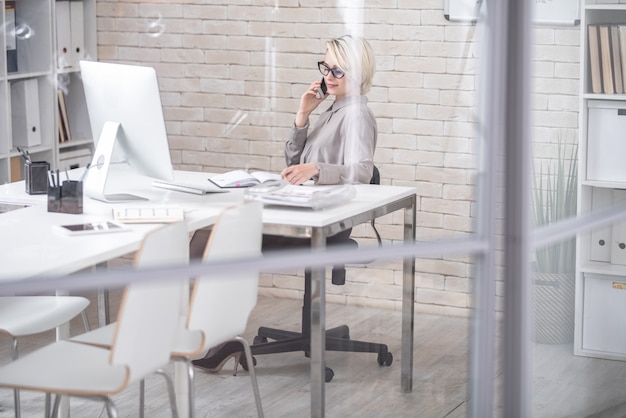 Empresária moderna falando por telefone no escritório