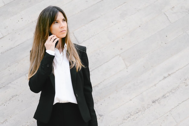 Empresaria molesta hablando por teléfono al aire libre