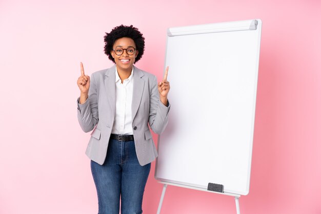 Empresária morena com quadro branco sobre fundo rosa isolado