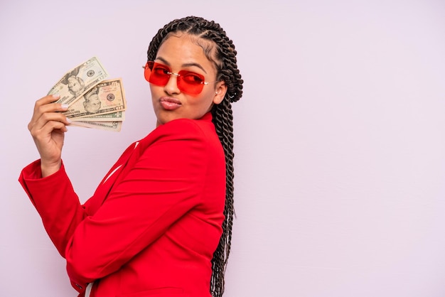 Empresária negra afro com tranças com notas de dólar