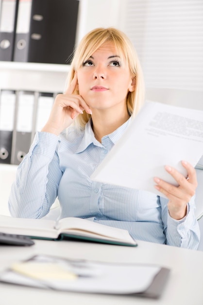 Empresária no escritório. Sentado à mesa e pensando.