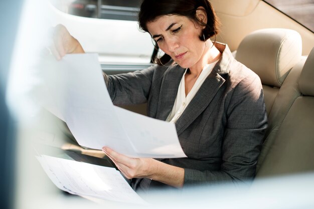 Empresaria ocupada trabajando coche dentro