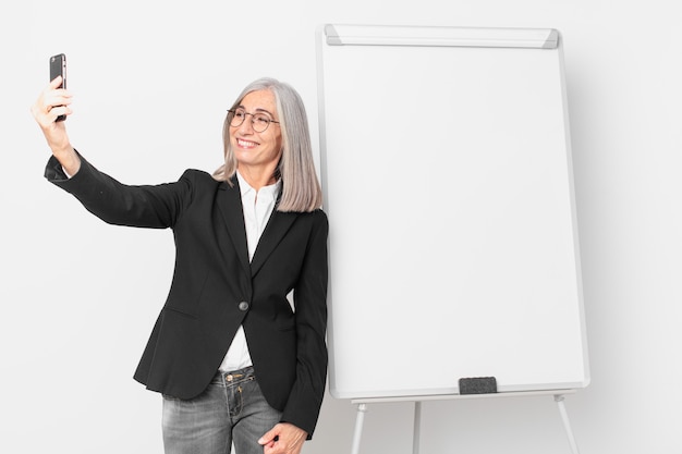 Empresaria de pelo blanco de mediana edad con un espacio de copia de tablero vacío.