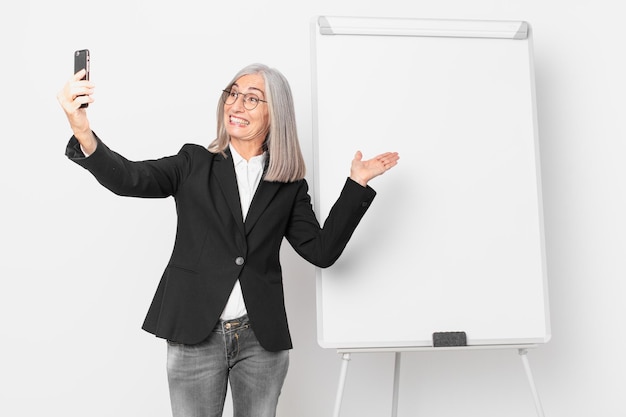 Empresaria de pelo blanco de mediana edad con un espacio de copia de tablero vacío.