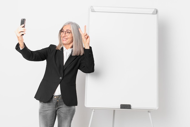 Empresaria de pelo blanco de mediana edad con un espacio de copia de tablero vacío.