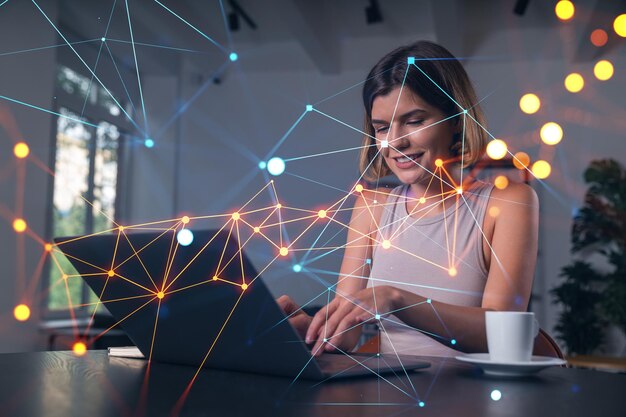 Foto empresária pensativa em roupas casuais digitando no laptop no local de trabalho do escritório com uma xícara de café conceito de trabalho distante tecnologia da informação de negócios na internet holograma de rede social