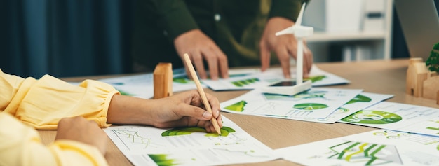 Empresária profissional participou de reunião de negócios verdes enquanto investidor masculino apresentava sobre o uso de energia limpa na mesa com documento ambiental espalhado Foco disponível Delineamento