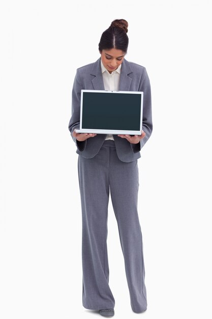 Empresaria que mira su computadora portátil en sus manos