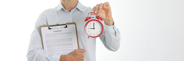 Empresária segurando contrato e hora do despertador para concluir o conceito de contrato comercial