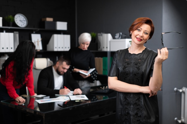 Empresária, segurando os óculos na camiseta dos trabalhadores de escritório, discutindo o projeto