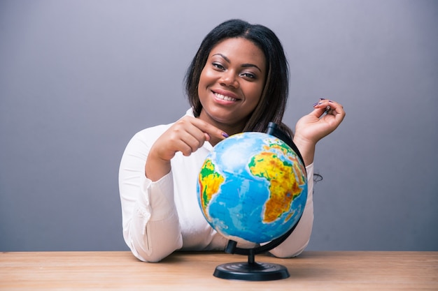 Empresária sentada à mesa com globo