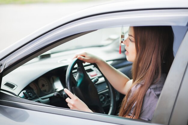 Empresaria sentada en el asiento del conductor en su automóvil