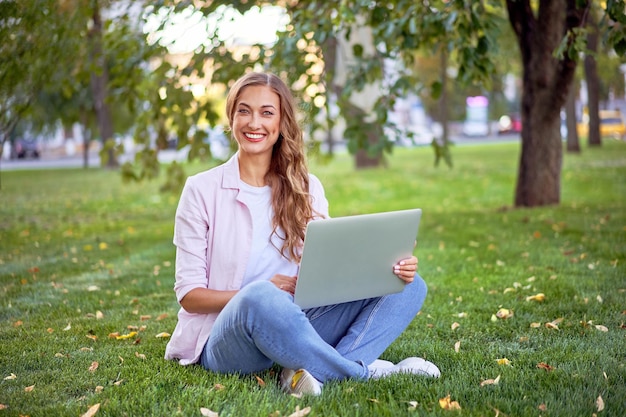 Empresária sentada no parque de verão usando laptop Empresário trabalhando remoto ao ar livre