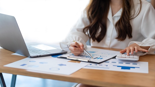 Empresária sentada planejando analisar investimento e marketing na mesa do escritório