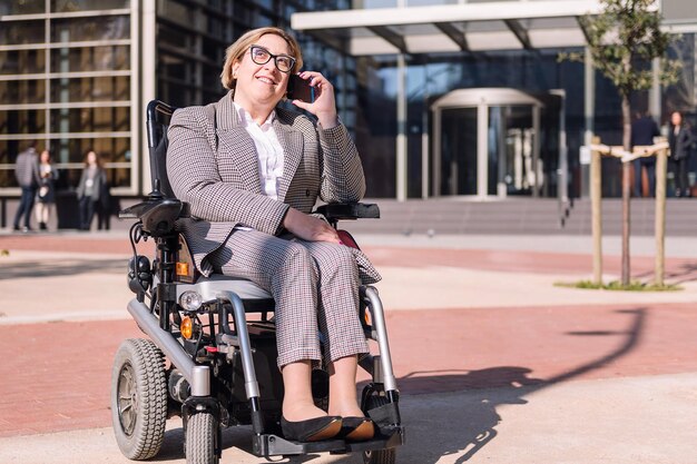 Empresaria en silla de ruedas hablando por teléfono