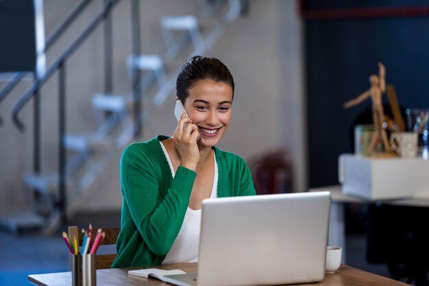 Empresaria sonriendo y llamando con su teléfono móvil