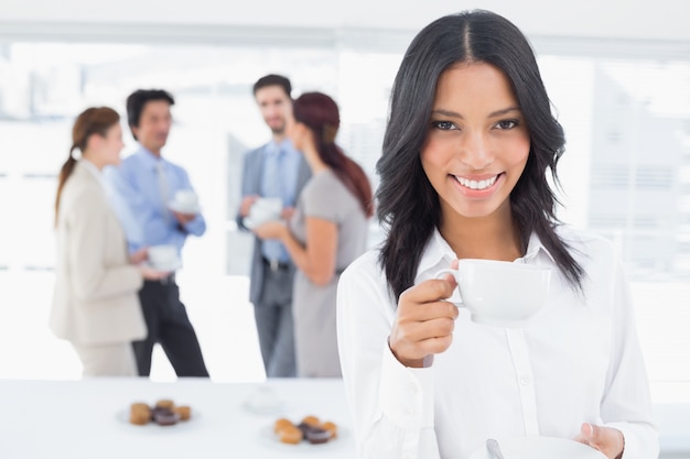 Empresaria sonriente con una bebida