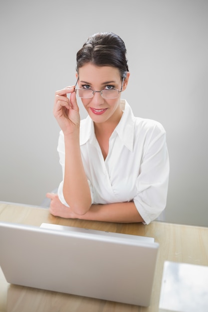 Empresaria sonriente con gafas con clase posando