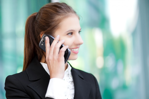 Empresaria sonriente hablando por teléfono