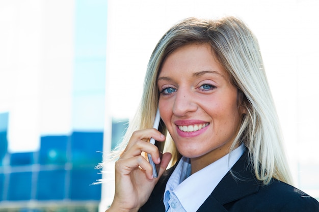 Empresaria sonriente que habla en el teléfono