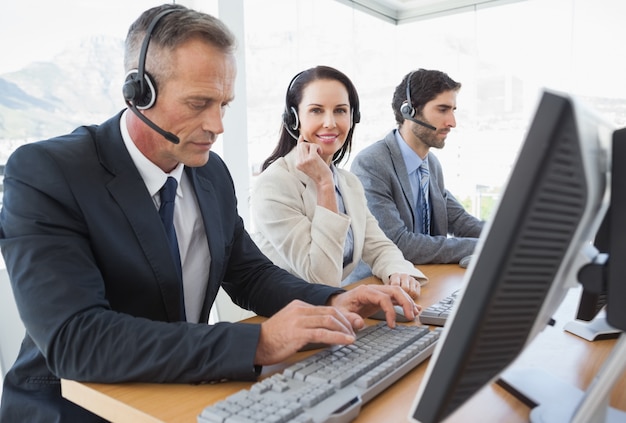 Empresaria sonriente que trabaja con los compañeros de equipo