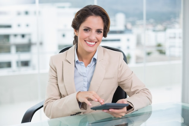 Foto empresaria sonriente que usa la calculadora