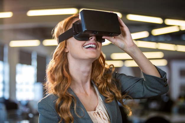 Foto empresaria sonriente que usa el simulador de realidad virtual