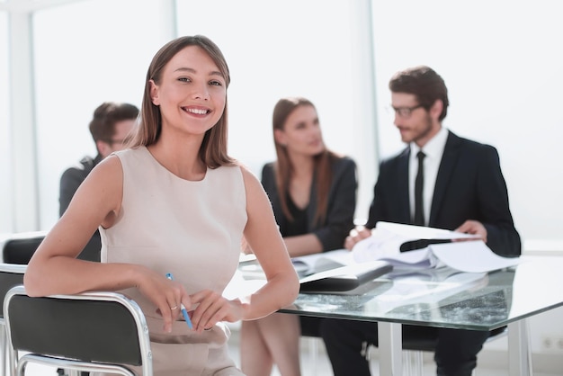 Empresaria sonriente sentada en la mesa de la oficina