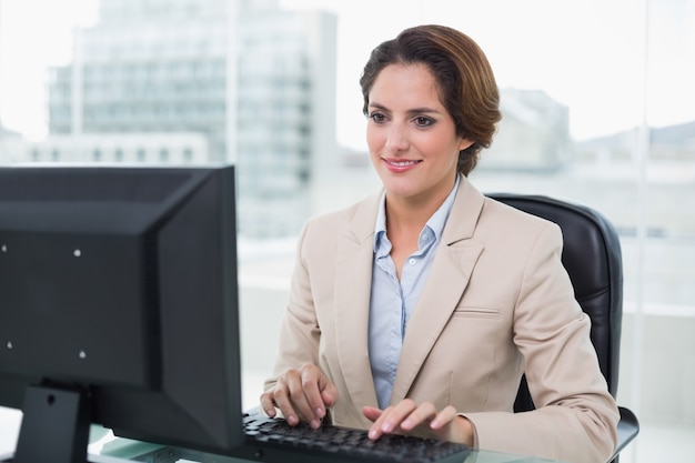 Empresaria sonriente, sentado frente a la computadora