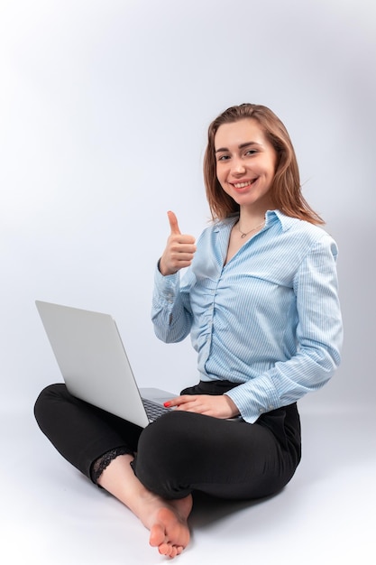 La empresaria sonriente se sienta con la computadora portátil en su regazo. aislado