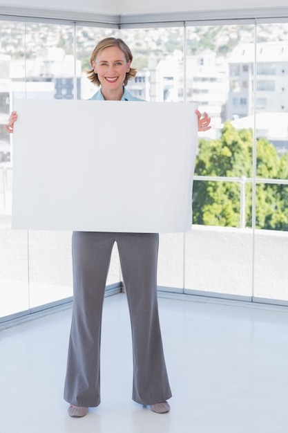 Foto empresaria sonriente sosteniendo cartel blanco grande
