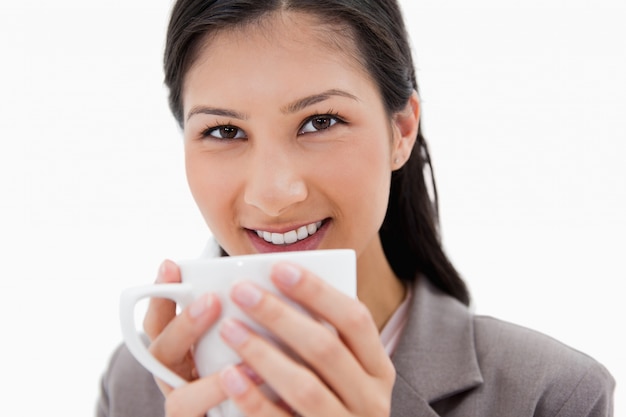 Empresaria sonriente sosteniendo la taza cerca